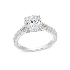 a diamond engagement ring with pave set diamonds on the shoulders and sides, in white gold