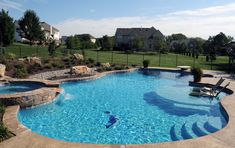 a large swimming pool with steps leading up to it and a lawn in the background