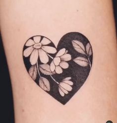 a black and white heart tattoo with flowers on the back of it's arm