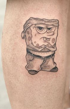 a small cartoon character tattoo on the right thigh, with an eyeball in it's mouth