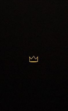 a black background with a yellow crown in the middle and one light shining on it