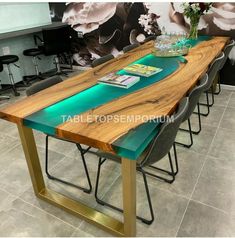 the table is made out of wood and has green glass on it, along with black leather chairs