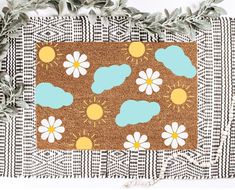 a door mat with flowers and clouds on it