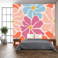 a bedroom with an orange and pink flower wall mural on the wall next to a bed