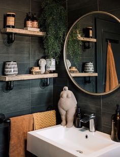 a bathroom sink sitting under a round mirror