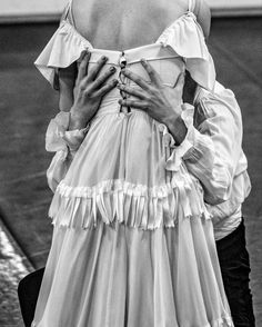 black and white photograph of a woman in a dress with her back to the camera