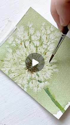 someone is cutting out a dandelion card with scissors