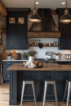 a kitchen with blue cabinets and wooden counter tops, two stools are in front of the island