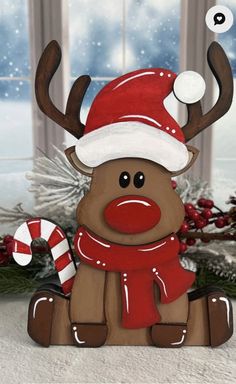 a wooden reindeer with a santa hat and scarf