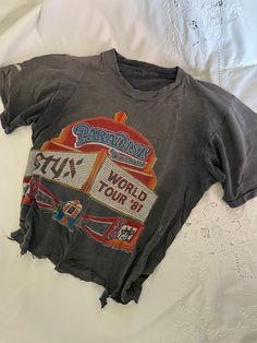 True Vintage 1980s Original Styx Rock Band Paradise Theatre 1981 World Tour Double Sided Thrashed Crop Tee Shirt Size On Tag: none Modern Size: M Measurements in inches, laid flat: (Double for circumference) Pit to Pit: 17 Waist: 17.5 Hip/bottom edge: 17.5 Length shoulder to bottom: 18.5 Shoulder seam to shoulder seam: 14   Cotton All vintage items have been given estimated ages based on quality, materials, design and features of the pieces. These are estimates and not exact.  All items are in wearable vintage condition, unless otherwise stated. We do our best to show any major issues like rips or discoloration in photos of the item.  Measurements are taken by hand. Vintage Tee Shirt Designs, Vintage Distressed Tops For Music Festival, Vintage Letter Print Tops For Music Festival, Retro Distressed Tops For Concert, Vintage Graphic Print Tops For Music Festivals, Graphic Tee With Vintage Print For Concert, Distressed Grunge Tops For Music Festivals, Grunge Distressed Tops For Music Festivals, 90s Letter Print Tops For Music Festivals