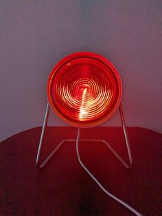 a red light sitting on top of a metal stand