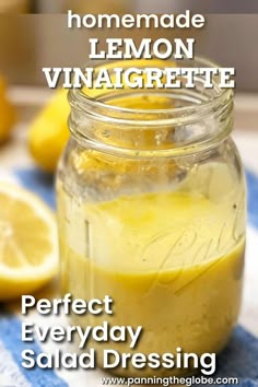 a mason jar filled with lemon vinaigrete sitting on top of a blue and white towel