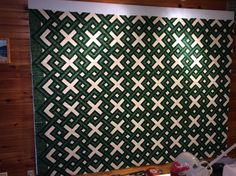 a green and white wall hanging on the side of a wooden wall next to a sink