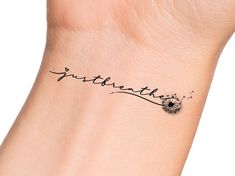 a dandelion tattoo on the wrist that says just breathe