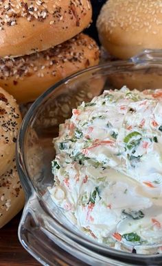 there are many bagels and dips in the glass bowl on the table together