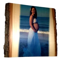 a pregnant woman standing in front of the ocean