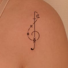 a tattoo on the back of a woman's left shoulder, which has a musical note and stars