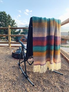 a blanket sitting on top of a chair next to a fire pit