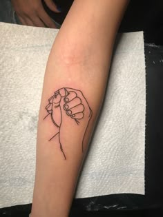 a woman's arm with a tattoo on it that has a fist in the middle