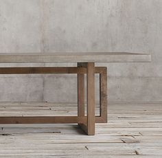 a wooden table sitting on top of a hard wood floor next to a white wall