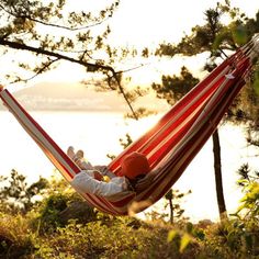 two people sitting in a red and white hammock