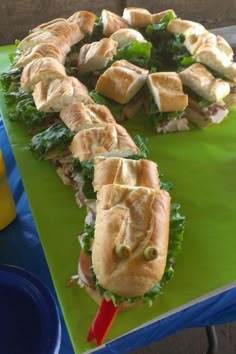 two sandwiches cut in half on a green cutting board