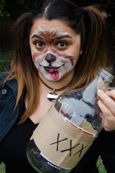 a woman with her face painted like a dog holding a bottle