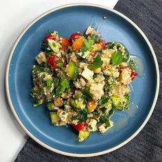 a blue plate topped with salad on top of a table