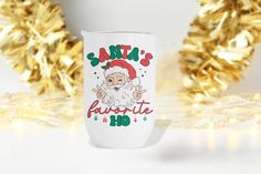 a white coffee cup with santa's favorite hoo on it and gold tinsel