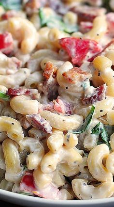 pasta salad with shrimp and spinach in a white bowl