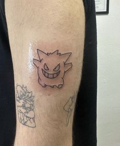 a man with a tattoo on his leg that has an image of a cartoon character