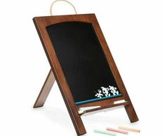 an easel with chalk and markers in front of it on a white background,