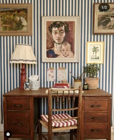 a desk with a chair, lamp and pictures on the wall