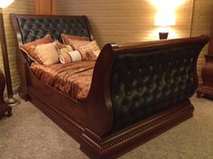 a large bed sitting next to two lamps on either side of the headboard and foot board