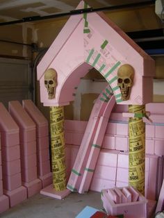 there is a pink house with tape wrapped around it and two skulls on the top