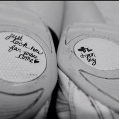 two pairs of shoes with writing on the soles that say just look how far you're gone