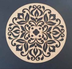 a white and black circular design on the side of a blue wall with an intricate pattern