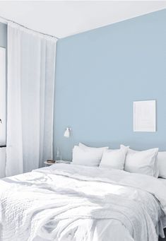 a white bed sitting in a bedroom next to a window