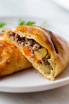 a close up of a pastry on a plate with meat and veggies in it