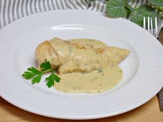 a white plate topped with meat covered in gravy