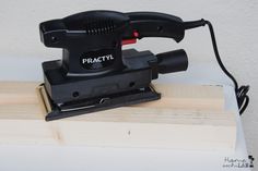 a machine that is sitting on top of a piece of plywood board with the word practi printed on it