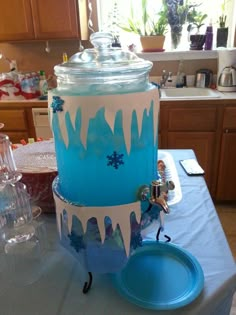 a blue and white cake sitting on top of a table next to a glass bowl