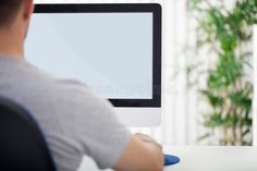 a man sitting at a desk in front of a computer monitor with a blank screen