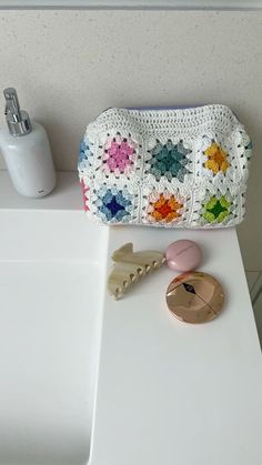 a crocheted purse sitting on top of a white counter next to a mirror