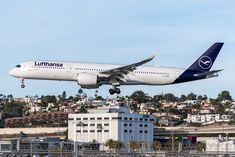 an airplane is taking off from the runway in front of a cityscape and buildings