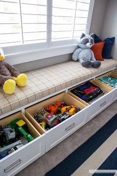 a toy storage bench with stuffed animals and legos in the bottom drawer, along with other toys