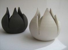 three black and white vases sitting next to each other on top of a table