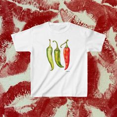 Turn up the heat in your casual attire with our vibrant white t-shirt, featuring a trio of chili peppers in varying shades of green and red. This tee is a celebration of flavor and spice, making it an ideal choice for those with a taste for the zestier things in life. **Sustainability & Ethics: Our commitment to ethical and sustainable fashion is evident in our choice of tee supplier, a proud member of the US Cotton Trust Protocol. This guarantees that our products are crafted from ethically grown, sustainably harvested cotton, backed by Oeko-Tex certification for safety and quality assurance. **Sizing & Fit: Precision in sizing is our hallmark. The measurements listed on our sizing chart are meticulously accurate. For a more fitted silhouette, we recommend opting for a size down. For a co Y2k Style Cotton T-shirt With Fruit Print, Food Graphic Tee, Hot Sauce Shirt, Baby Tees Y2k Funny, Vintage Red Hot Chili Peppers Shirt, Sweat Suits Outfits, Chilli Peppers, Shirt Coquette, Baby Graphic Tees