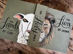 two book covers with animals painted on them sitting on a wooden table next to each other