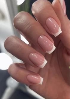 a woman's hand with french manies and white tips on her nail polish